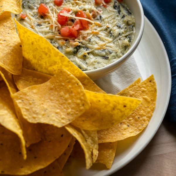 Spinach artichoke dip topped with diced tomato, served with tortilla chips.